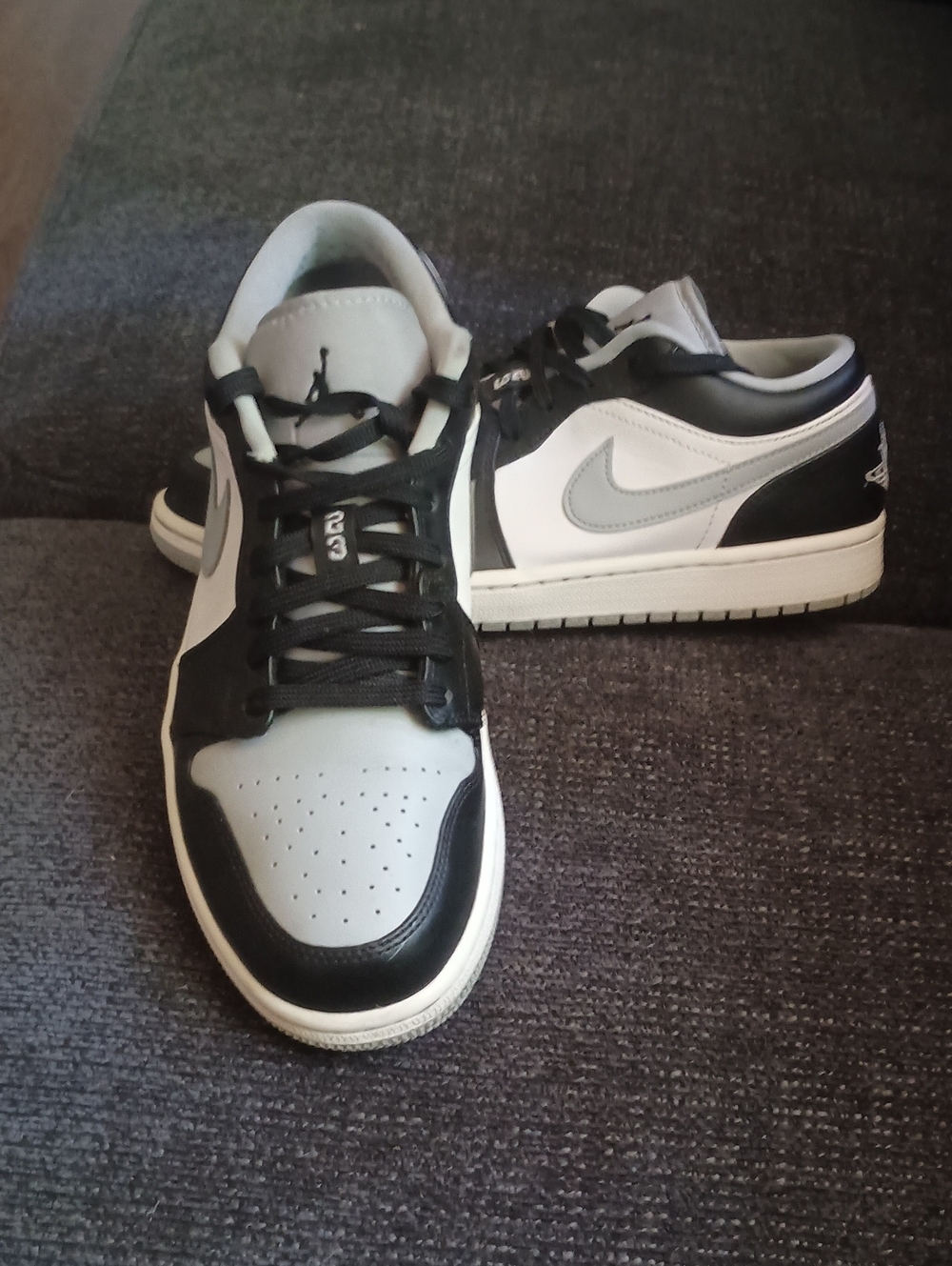 Nike Air Jordan 1 Low sneakers, featuring a black and gray leather design with a